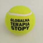 piłka tenisowa, klasyczna, żołta, z czarnym nadrukiem "globalna terapia stopy"